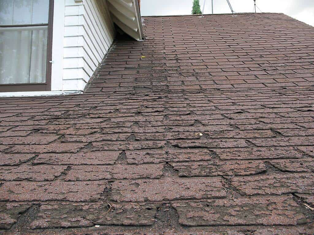 signs of roof storm damage on shingles near eave