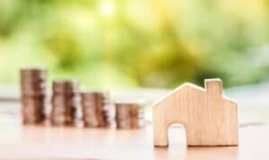 money behind a toy house representing roof replacement financing