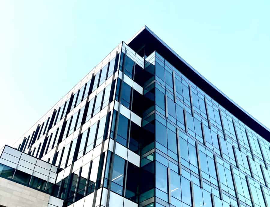 low angle of a glass covered commercial building with a TPO roof