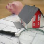 a model of a house on a stack of papers representing roof financing