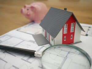 a model of a house on a stack of papers representing roof financing